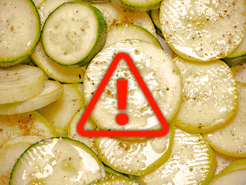 Healthy zucchini slices with a caution icon indicating food safety concern or allergen warning.