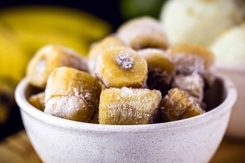Alt text: Frozen banana and apple dog treats in a white bowl, healthy snacks for dogs.