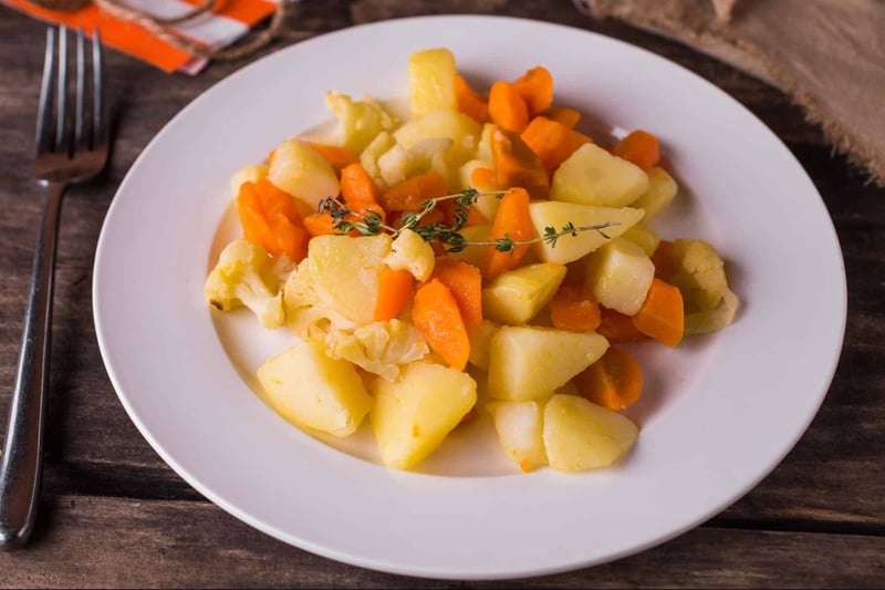 Healthy dog food with carrots, potatoes, cauliflower, and herbs.