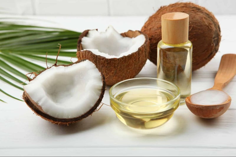 Coconut oil in a glass bowl with coconut halves, a small bottle, and wooden scoop, natural dog wellness supplement.