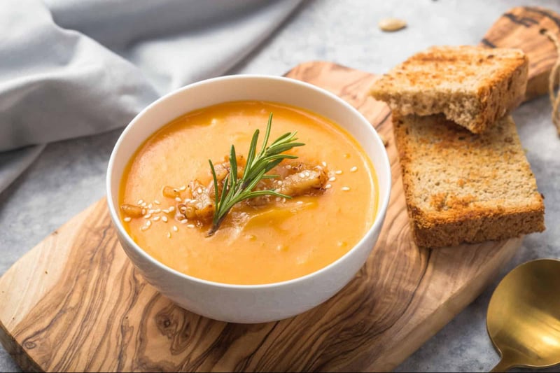 Healthy dog food bowl with nutritious soup and wholegrain toast on wooden board.
