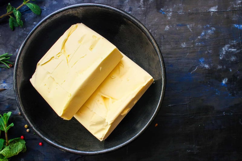 Bright yellow cheddar cheese on black bowl for dog-friendly snacks.