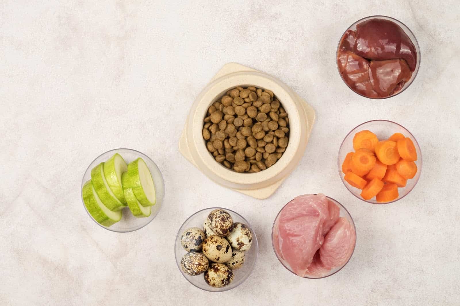 Fresh ingredients for homemade dog food, featuring meat, veggies, and supplements for nutrition.