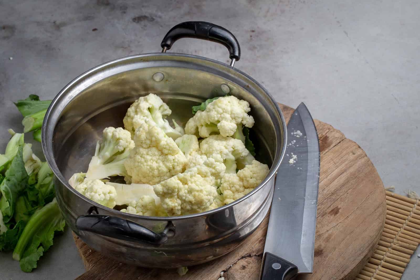 Fresh cauliflower ready for cooking or steaming on a kitchen counter.