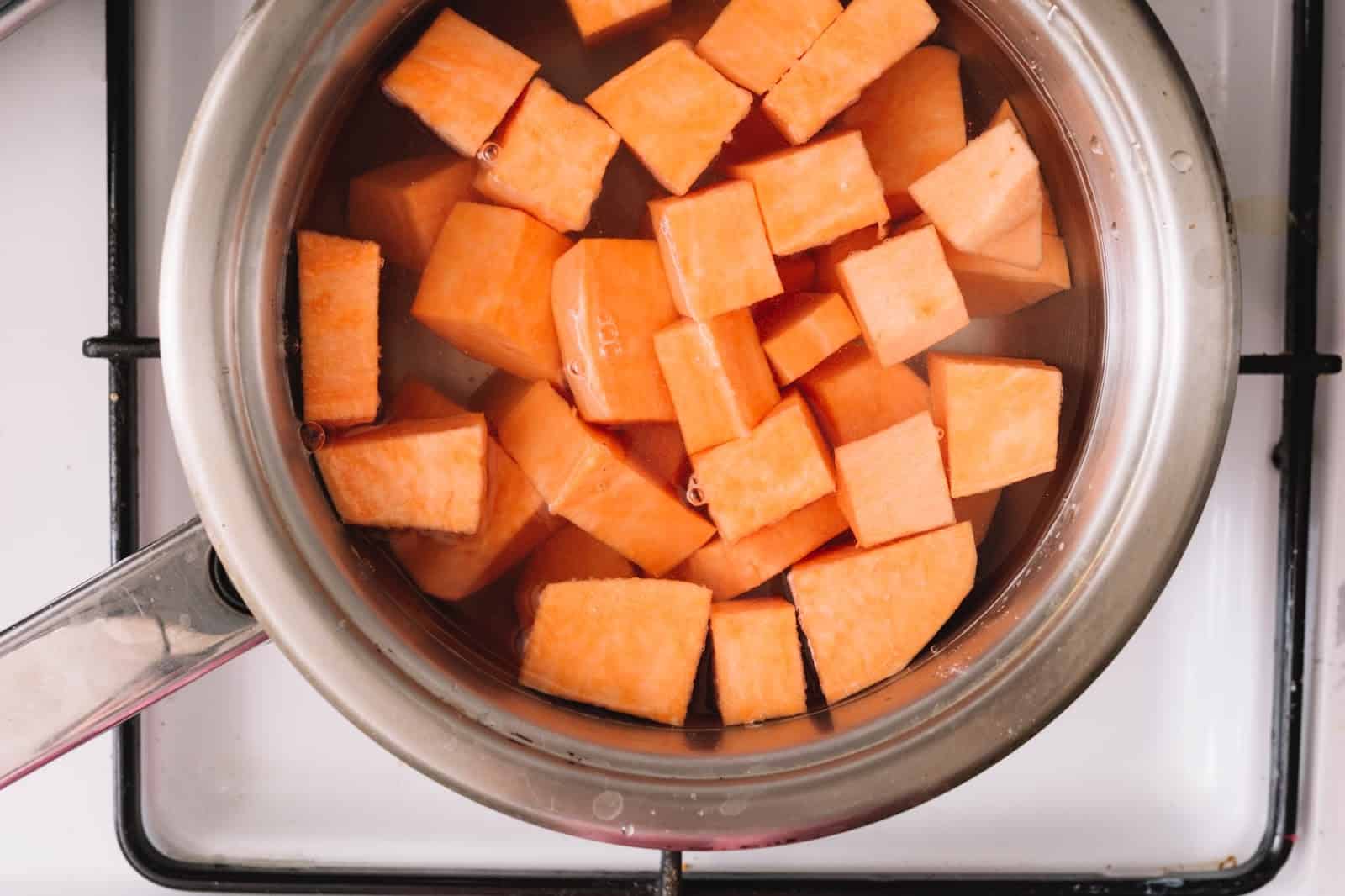 Healthy DIY dog treats, sweet potato cubes cooking for pet snacks preparation.