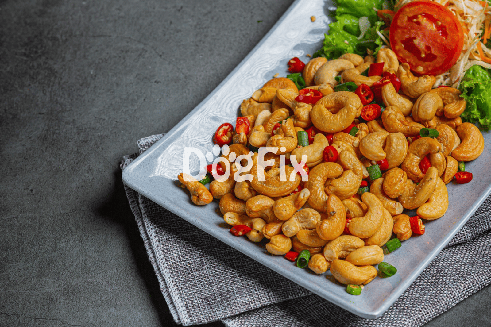 Delicious roasted cashews topped with chili peppers and herbs, served on a stylish plate for a healthy snack or appetizer.