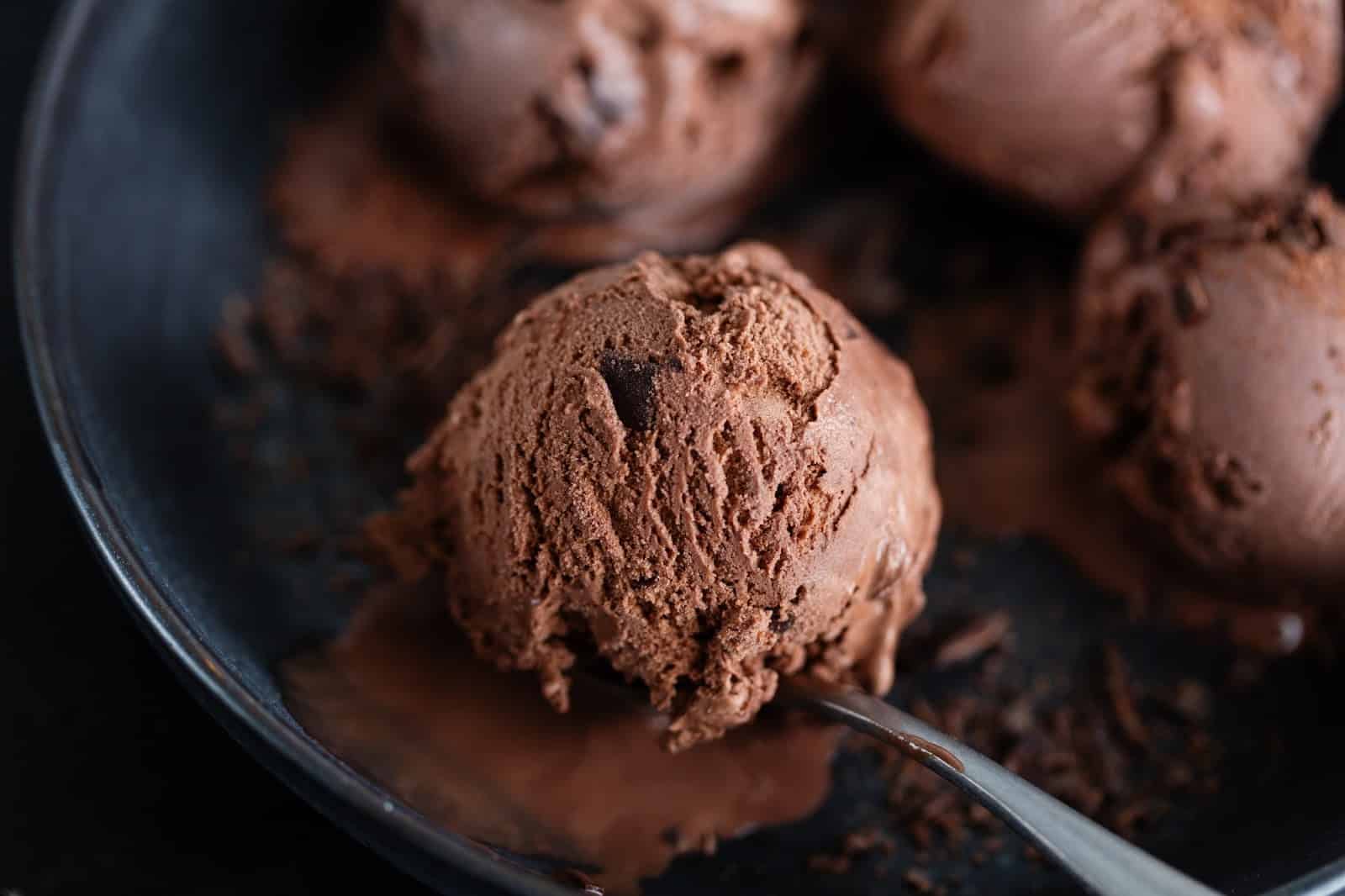 Creamy chocolate ice cream scoops in a bowl, perfect for dog-loving dessert enthusiasts.