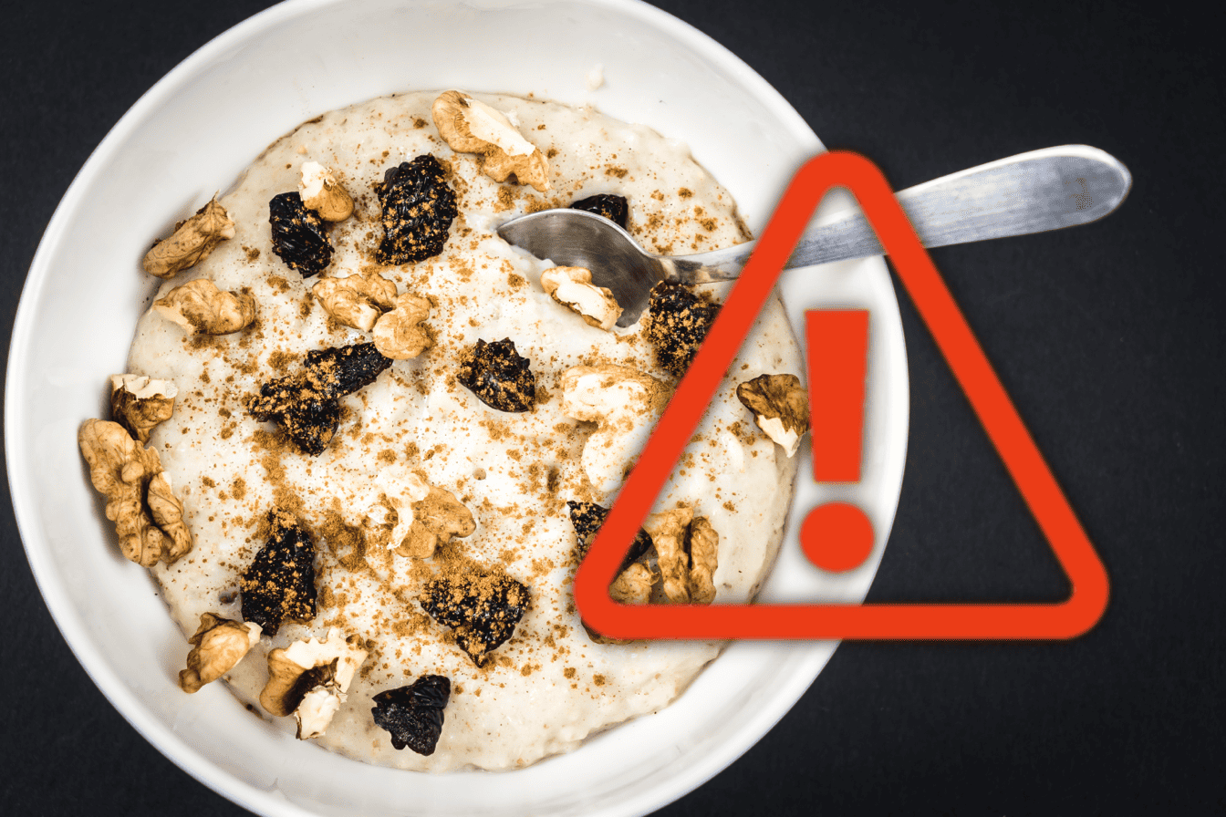Image showing a bowl of creamy dog-safe dessert with nuts and dried berries on a black background, with caution warning overlay.