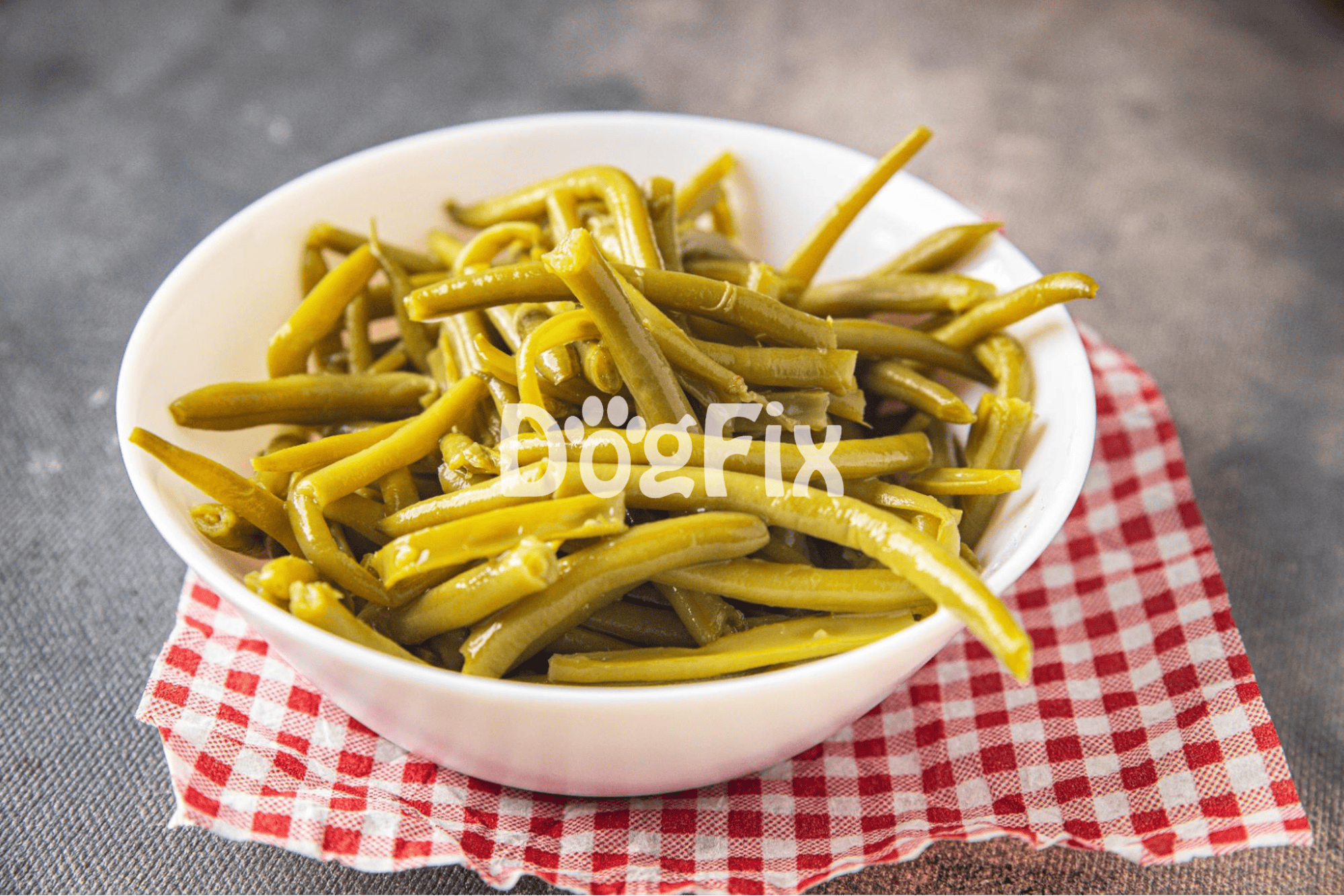 Healthy dog-friendly steamed green beans in a white bowl on a red checkered cloth.