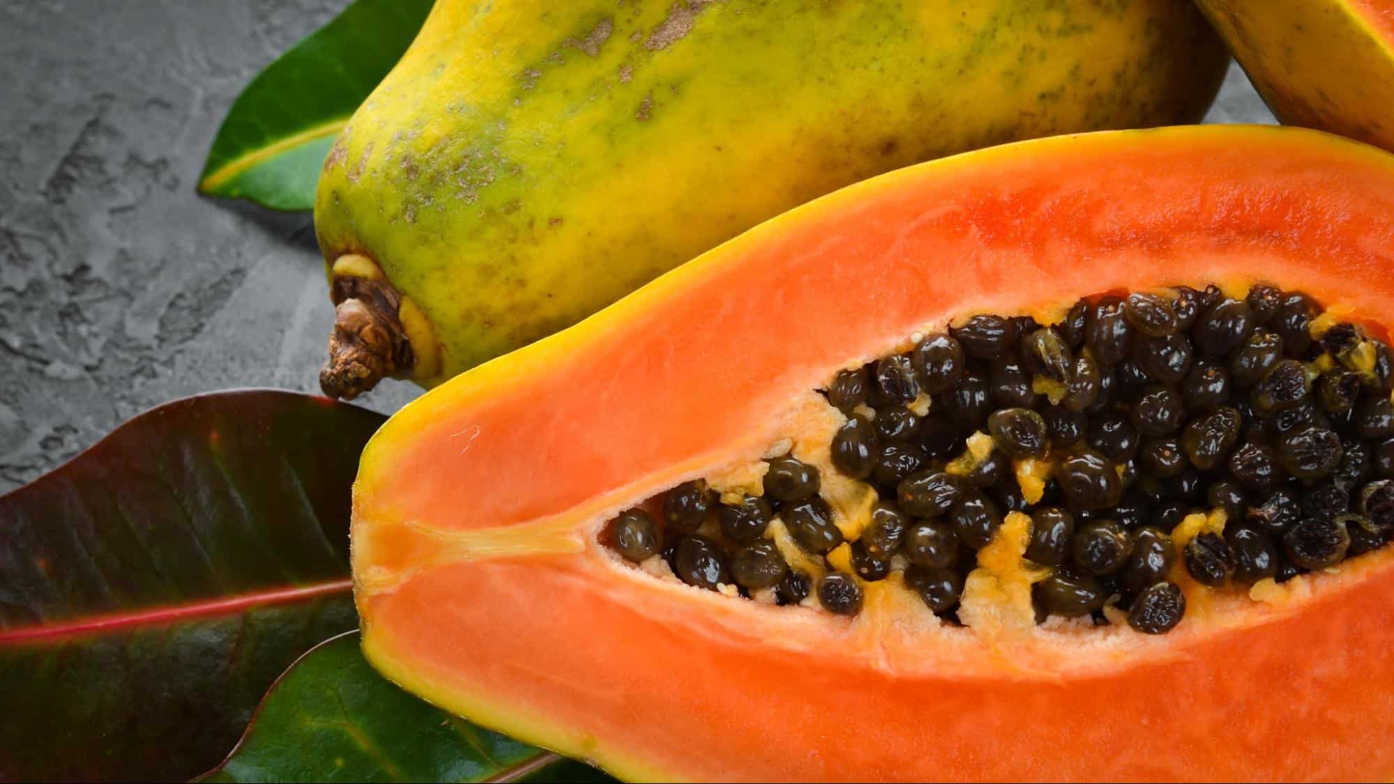 Fresh papaya fruit with bright orange flesh and black seeds, ripe and delicious.