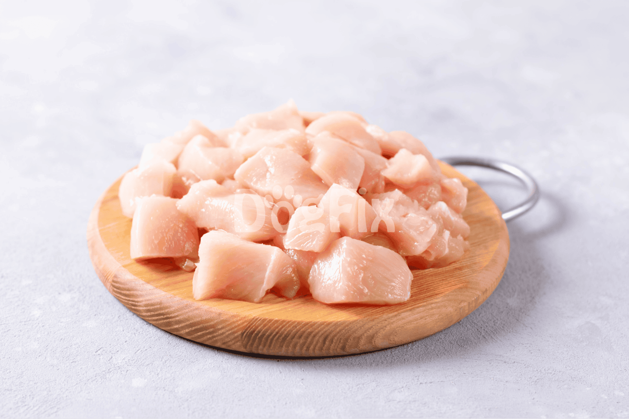 Raw chicken cut into pieces on a wooden board, ideal for homemade dog food.