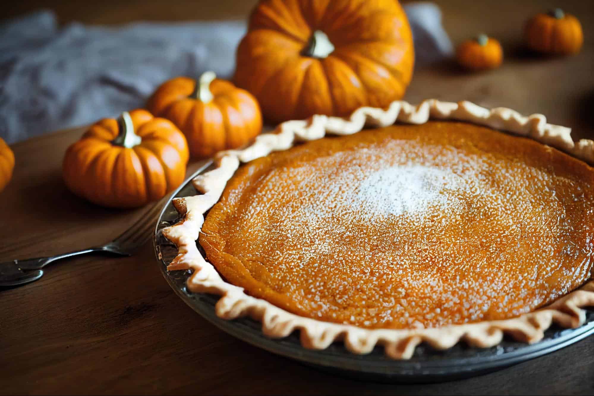 Delicious homemade pumpkin pie with whipped cream, perfect for fall seasonal celebrations.