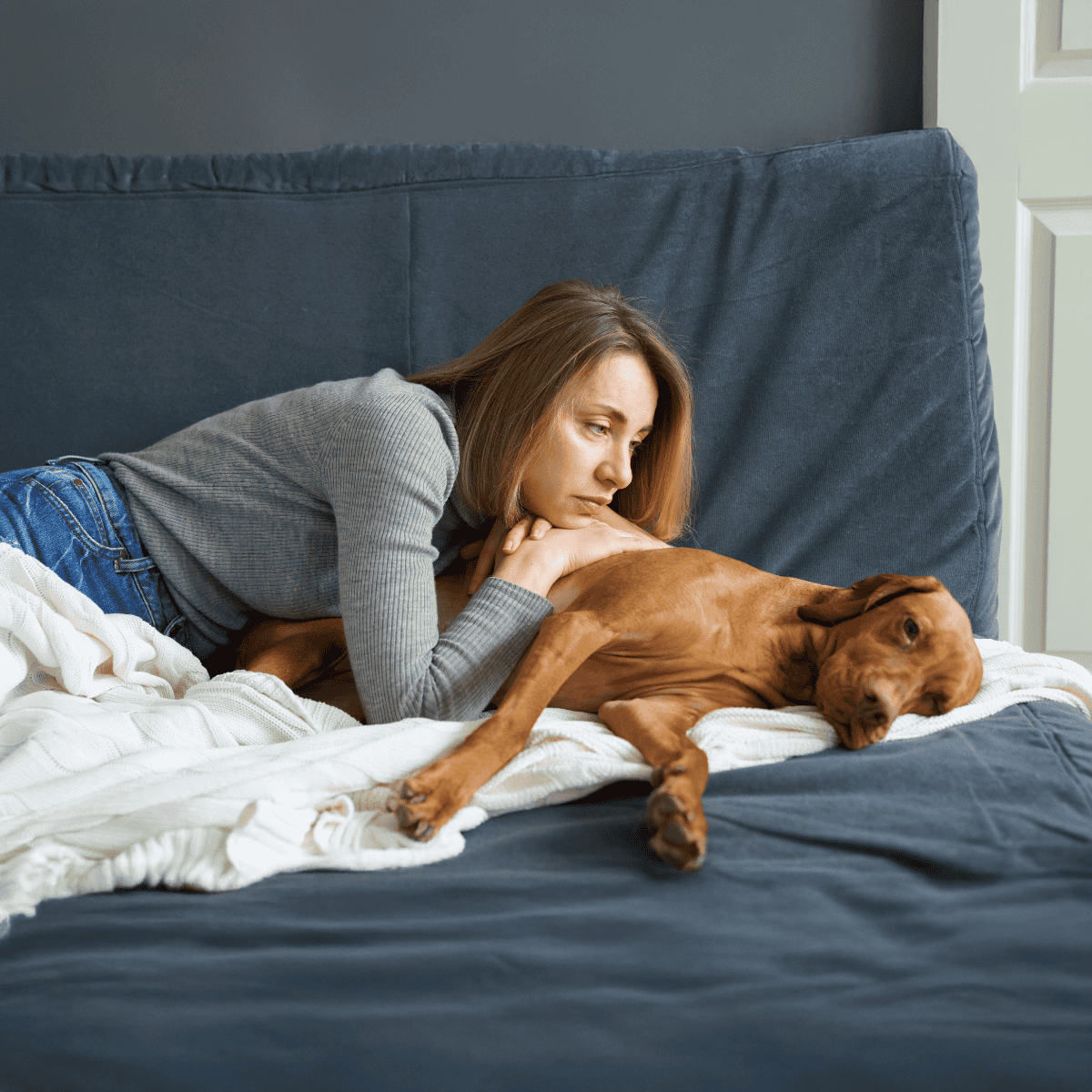 Happy woman relaxing with her dog on bed.