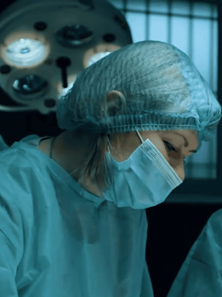 Surgical nurse preparing for operation in sterile environment.